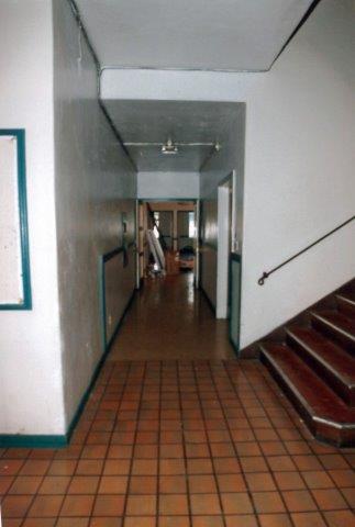 Before: Interior view of school entrance foyer facing north with corridor adjacent to stairs.